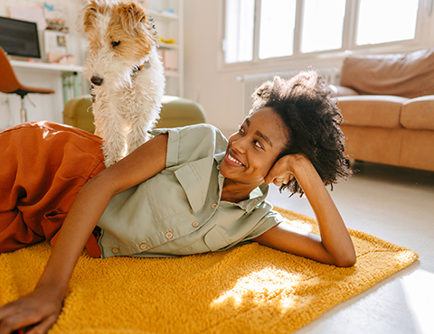 IMAGE: a woman laying on the floor looking at her dog