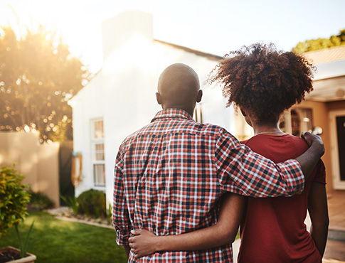 IMAGE: Back of a couple looking at a house