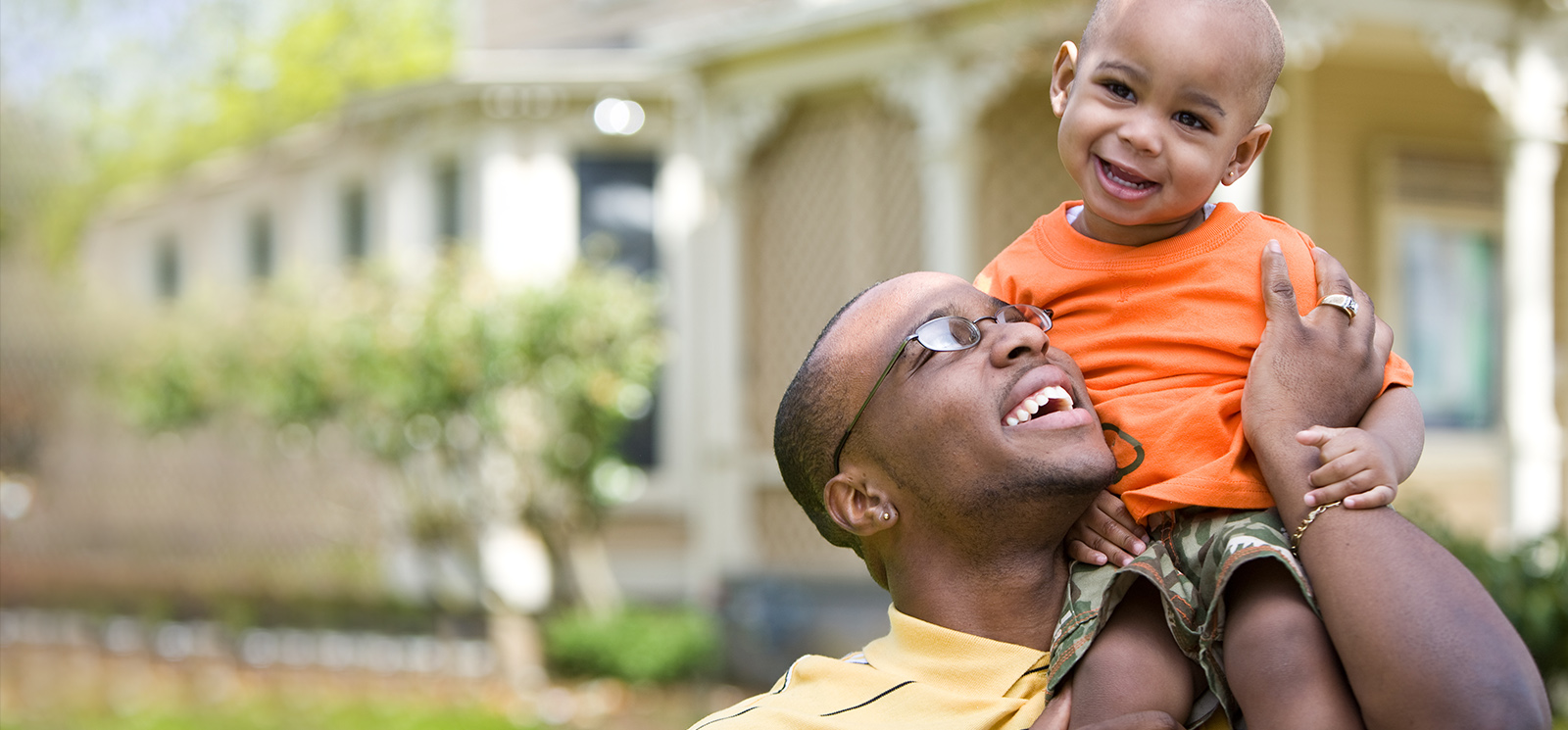 IMAGE: Dad holding son on his shoulder both smiling
